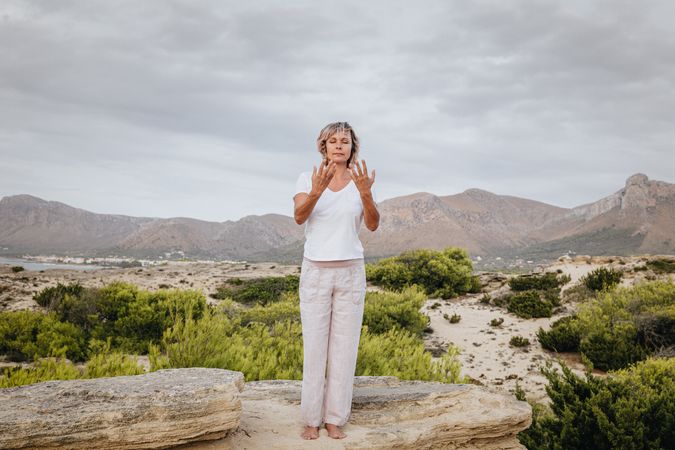 Barefoot woman meditating on stone