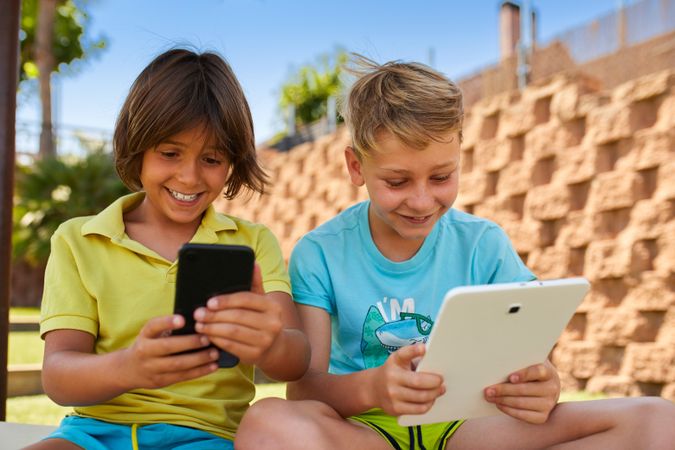 Boys using tablet in garden
