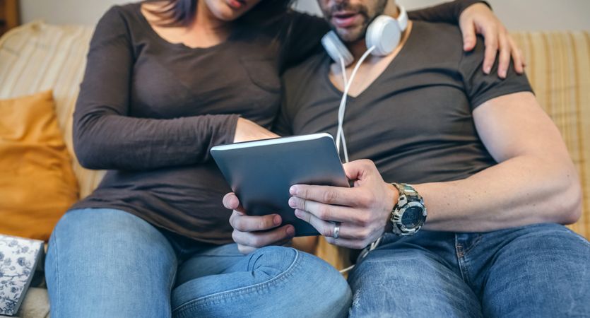 Pregnant with her partner looking at the tablet