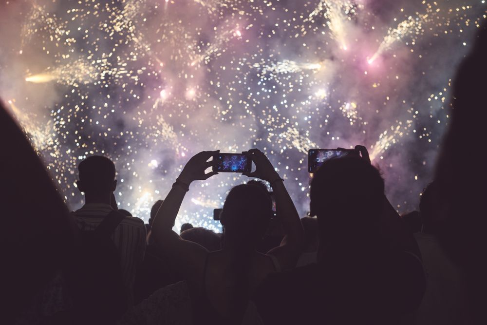 Back of concert goers taking picture of lights