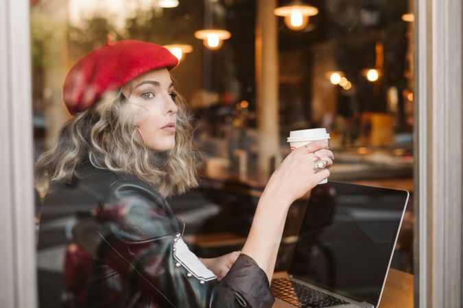 Dreamy woman using laptop in cafe