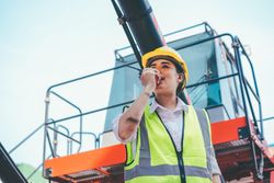 Woman on walking talkie working in logistic business, shipping and delivery