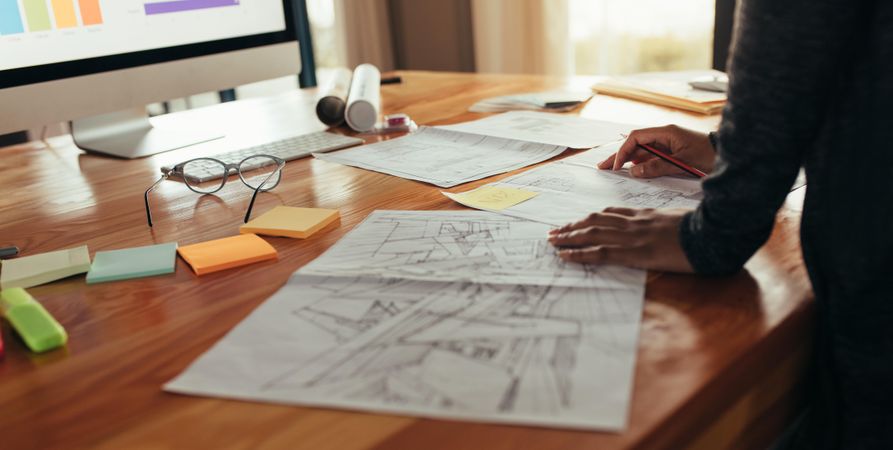 Close up of woman designer with house plan working at her desk