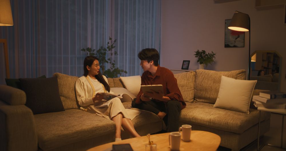 South Korean Partners Sitting on a Couch, Female Reading a Trendy Magazine,