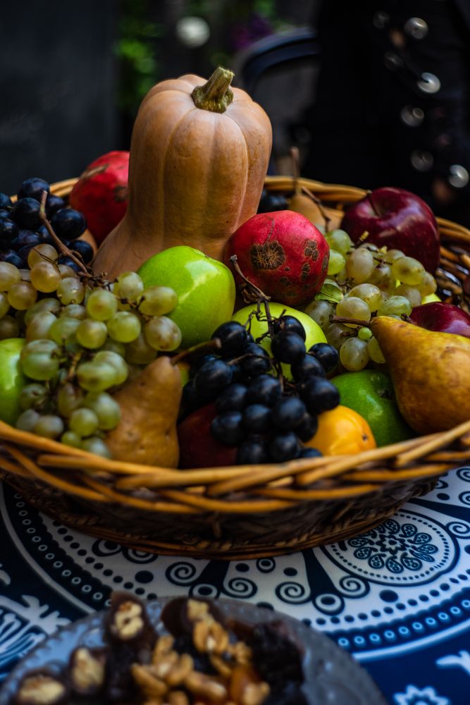 Bowl full of squash, grapes, pear and pomegranate