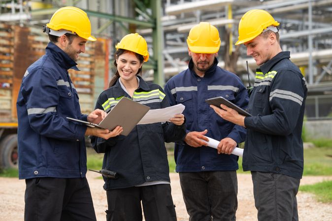 Group of engineer workers checking project at petrochemical factory or refinery oil plant industrial.