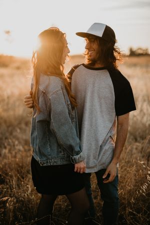 Hipster couple bonding on field in sunlight