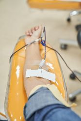 Arm of female patient giving blood in hospital