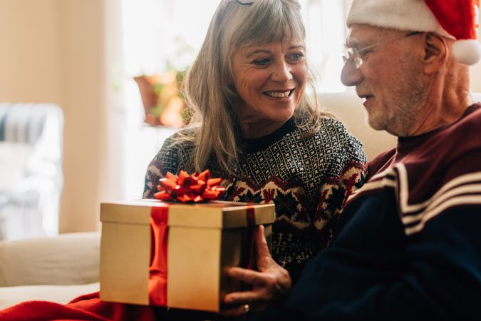 Older woman giving a gift to her husband for christmas