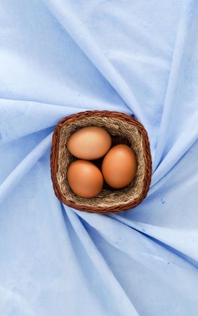 Three eggs in rustic basket