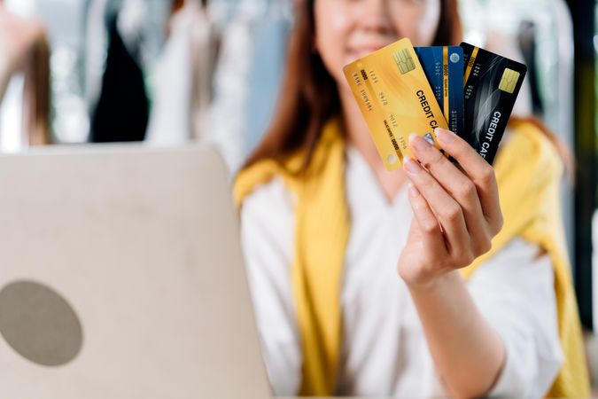 Happy woman showing credit card for online shopping
