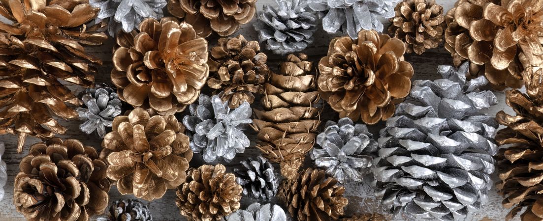 Filled frame of gold and silver pine cone decoration ornaments on rustic wood for Christmas or New Year