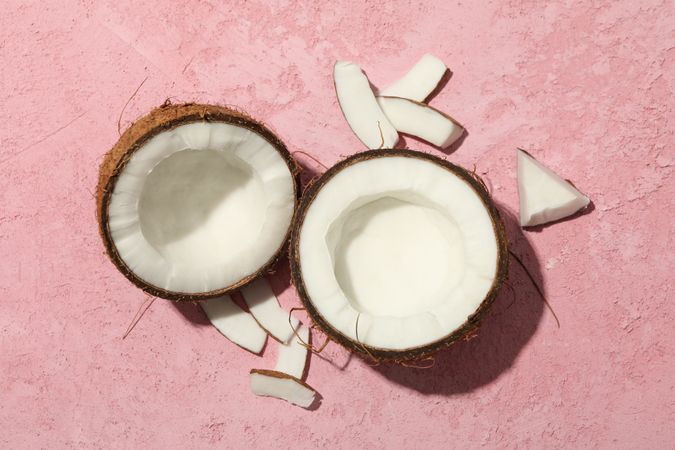 Coconut on pink background, top view. Tropical fruit