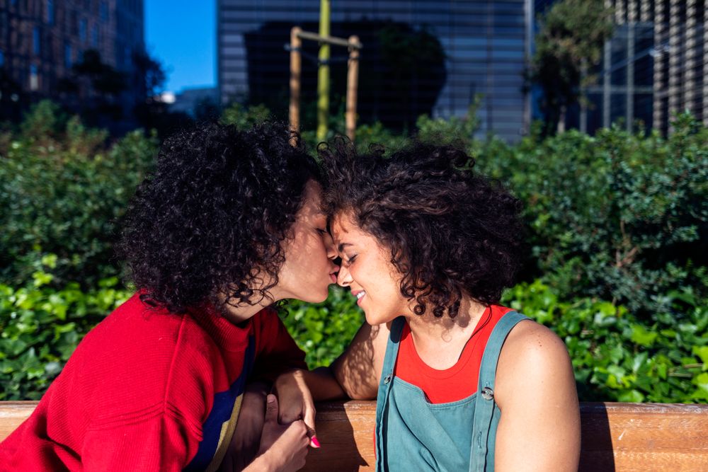 Female couple being affectionate in park together