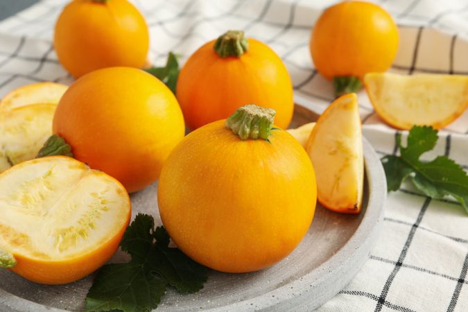 Tray with round zucchini on napkin background