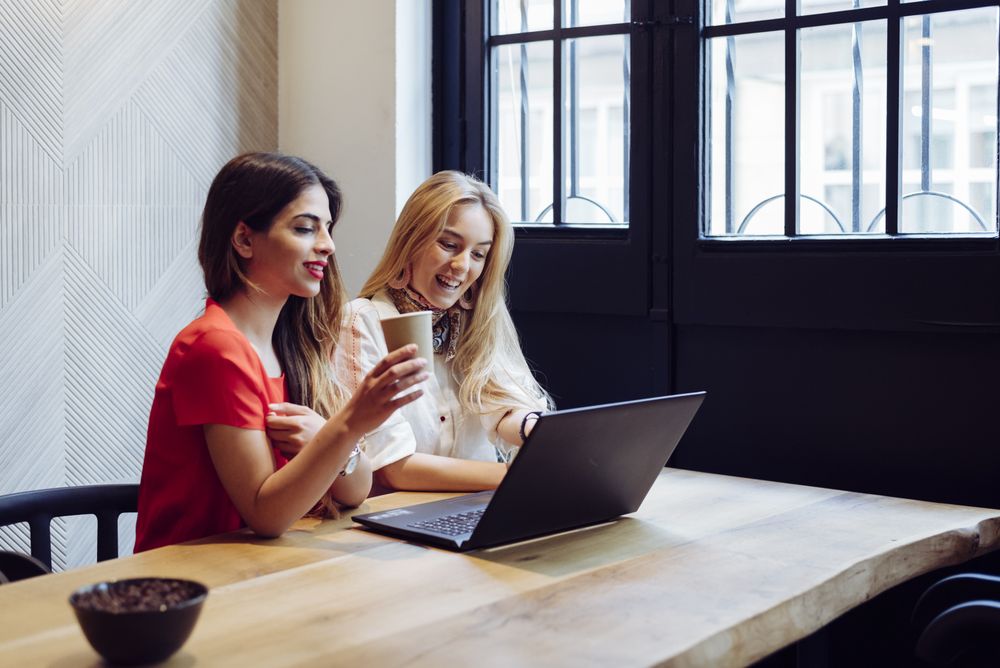 Women working on computer in cafe