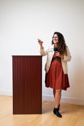 Woman at podium holding microphone and remote