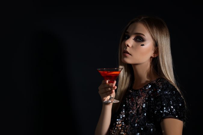 Concept of Halloween, young woman on dark background