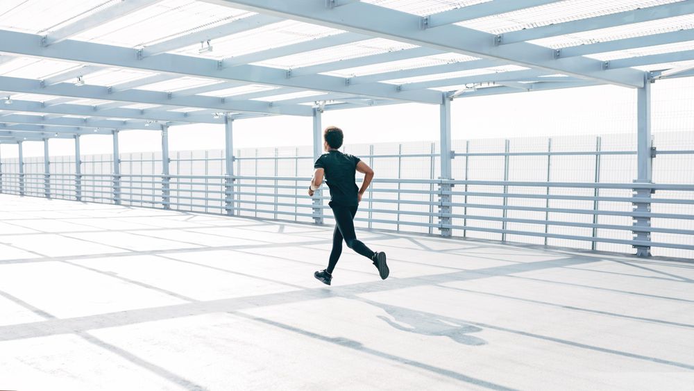 Man running on modern bridge