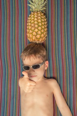 Happy child with sunglasses and pineapple in head