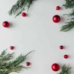 Christmas layout made of branches and baubles on light background