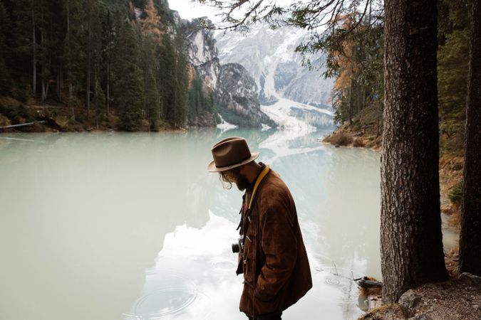 Man delighting in views near lake and mountains