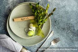 Easter concept with branch and green decorative eggs on ceramic plates with space for text bYqG66