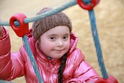 Happy child climbing rope ladder on playground