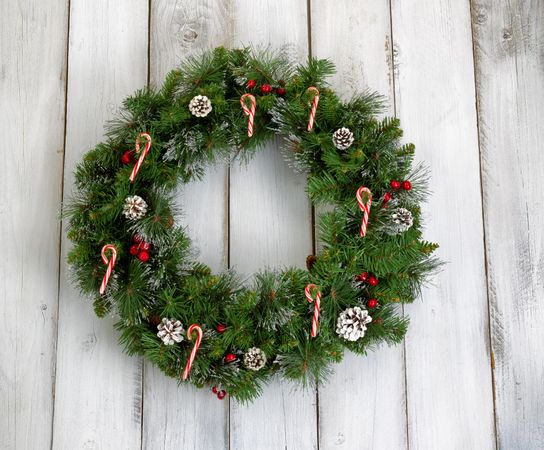 Christmas wreath with decorations on rustic white wood
