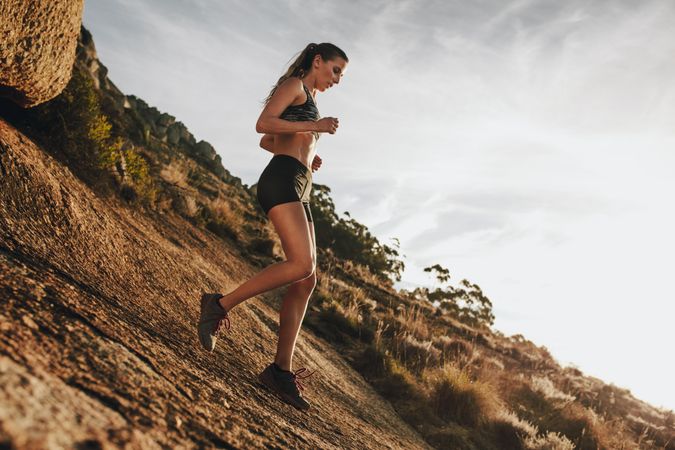 Woman trail runner training for down hill run