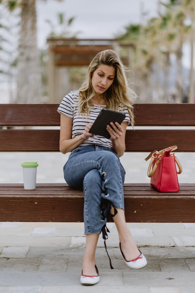 Woman sitting on bench and using tablet