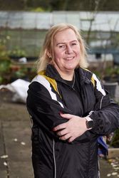 Portrait of woman standing outside wooden shed