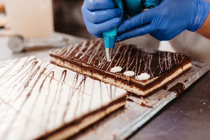 Crop confectioner decorating small cakes