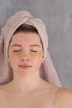 Applying eye patches in skincare routine.