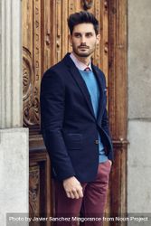 Attractive man in the street wearing elegant suit in front of ornate door 5keNDb