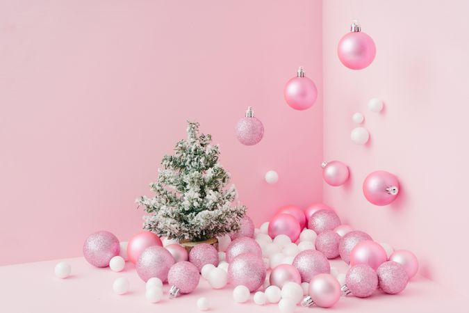 Baubles in a variety of pink shades in corner of pink room with Christmas tree
