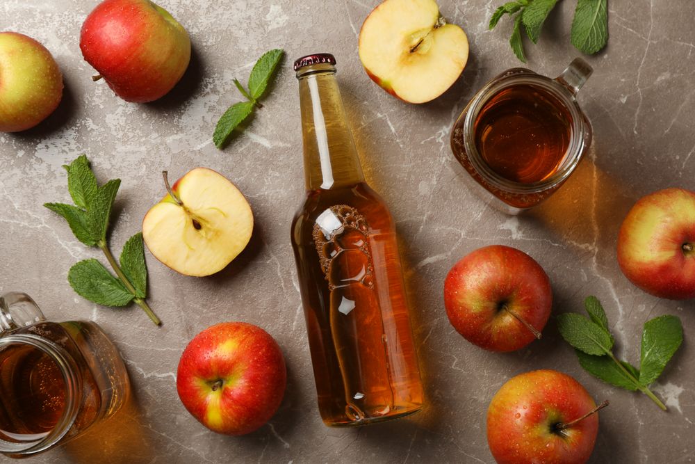Composition with cider and apples on gray background
