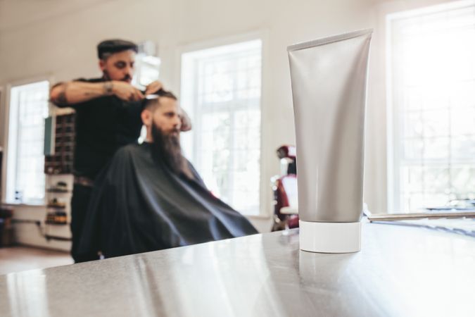 Focus on grey tube sitting on counter in barbershop
