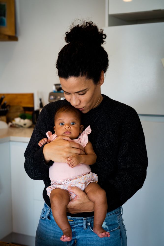 Mother holding baby in kitchen