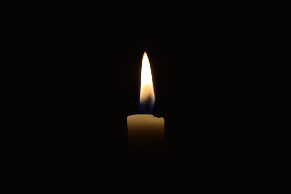 Side view of candle lit in the dark