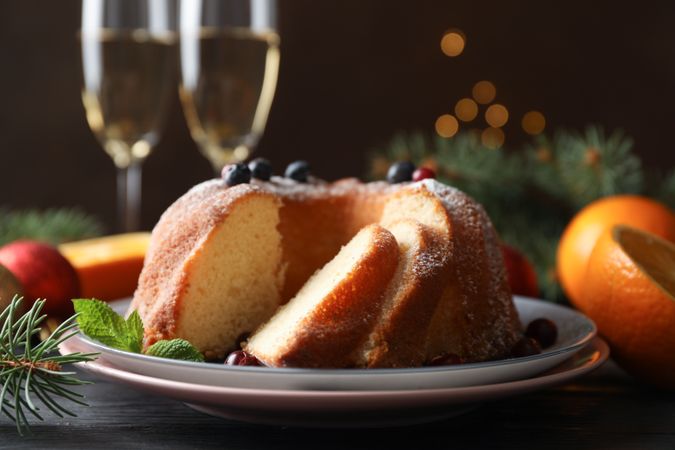 Cake with powdered sugar, berries and mint on wooden background, close up