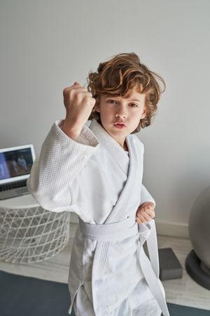 Boy practicing defense blocks at home