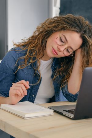 Smiling woman writing in planner at table
