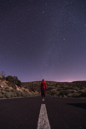Traveler standing on empty road at night