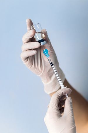 Hand holding syringe with vaccine. Covid-19