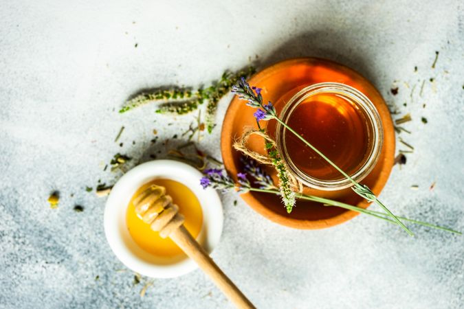 Floral honey concept with glass of honey and dried flowers