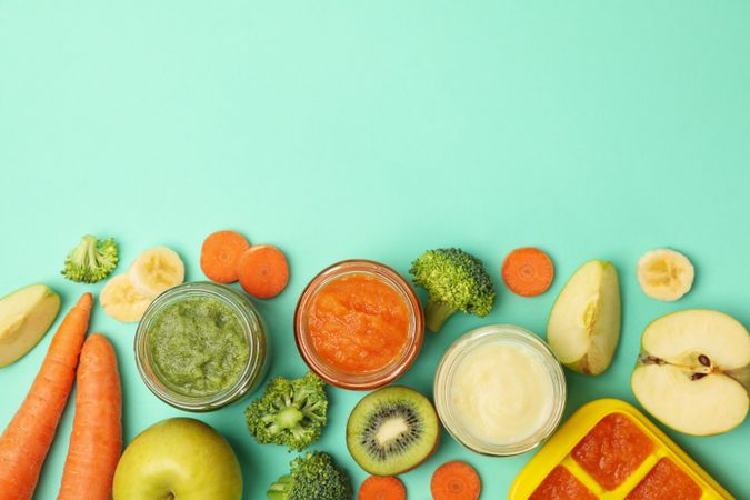 Composition with baby food on mint background, top view