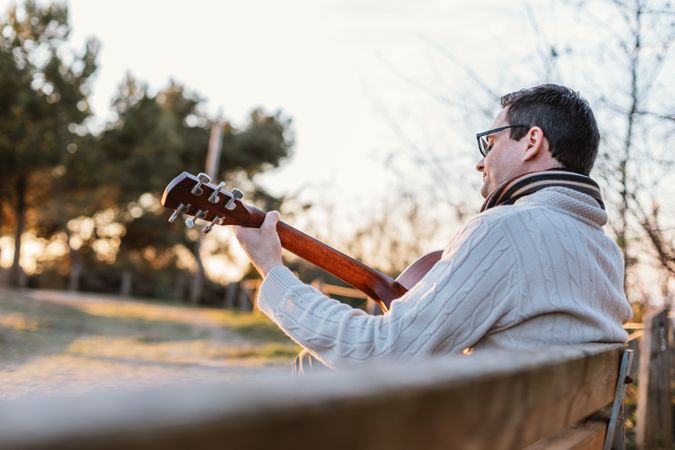 Man playing the guitar on the outside