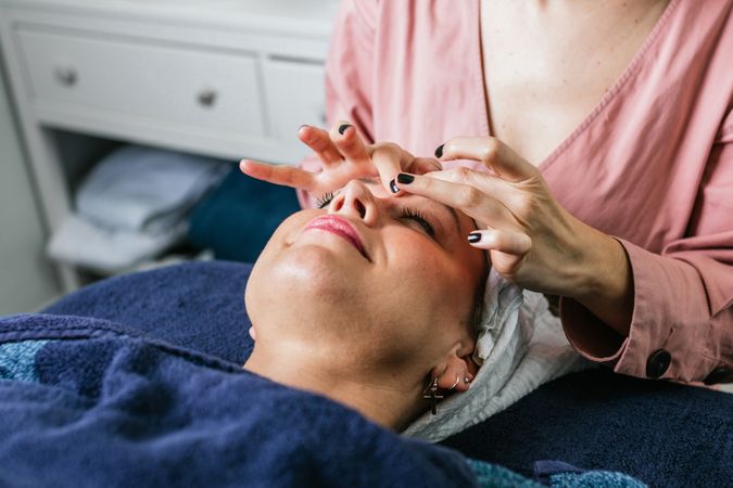 Anonymous masseuse doing massage for woman in spa salon