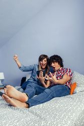 Couple excited by something they're watching on tablet